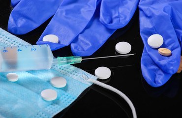 Medical still life. Syringe, medical mask with gloves, pills. Diagnosis, protection and treatment...