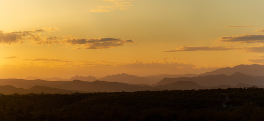 A Panorama of the sun setting behind mountains in the Sonoran Desert of Arizona.