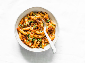 Vegetarian lentil Bolognese sauce with penne pasta on a light background, top view. Healthy eating...
