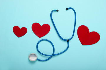 Stethoscope with hearts on a blue pastel background. Top view