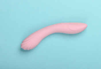 Sex toy for women on blue background. Top view, minimalism