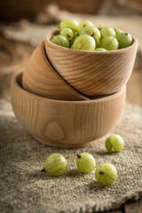 Fresh gooseberry in a wooden bowl.