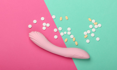 Sex toy and pills on pink blue background. Sex stimulants. Top view