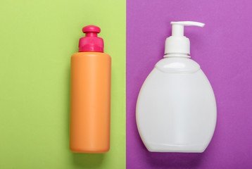 Shampoo and gel bottles on purple green background. Skin and hair care. Hygiene and cosmetics. Beauty flat lay. Top view