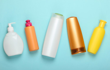 Shampoo bottles on blue pastel background. Hair care. Hygiene and cosmetics. Beauty flat lay. Top view