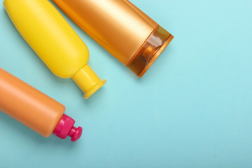 Shampoo bottles on blue background. Hair care. Hygiene and cosmetics. Beauty flat lay. Top view. Copy space