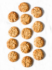 Delicious oatmeal gluten free cookies with walnuts on a light background, top view