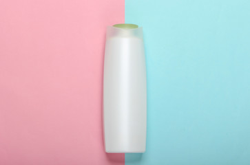 Shampoo bottle on pink blue pastel background. Hair care. Hygiene and cosmetics. Beauty flat lay. Top view
