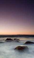 Fototapeta na wymiar long exposure seascape with rocks and milky sea