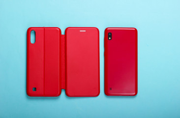 Smartphone with red leather protective case on a blue background