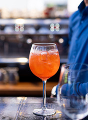 Aperol is an alcoholic cocktail. Orange. Cold drink with ice cubes. The glass is on the bar. Refreshing cocktail for hot weather. Menu for restaurants, cafes and bars.