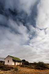 abandoned house in the Karoo with stormy clouds