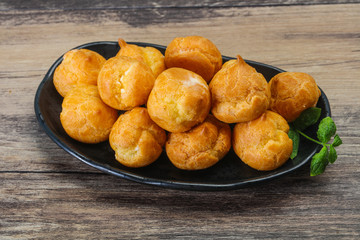 Sweet tasty profiteroles heap in the bowl