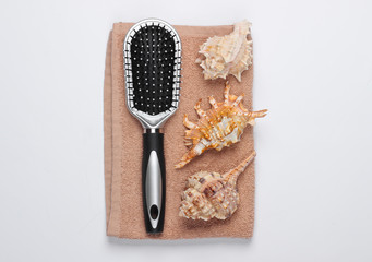 Beauty products. Seashells, towel, hairbrush on white background. Top view. Flat lay