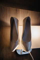the bride’s shoes are hanging on the lamp