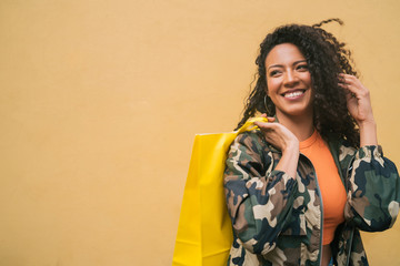 Afro american latin woman holding shopping bags.