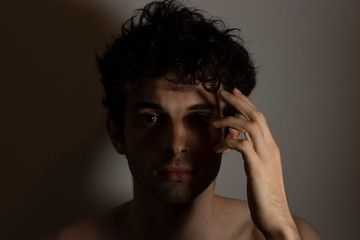 Young man teenager touching head hand curly hear