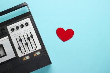 Music lover concept. Retro audio tape recorder with heart on blue background. Retro 80s. Top view