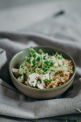 salad with quinoa, microgreens, cucumber, cottage cheese searved on gray background with linen napkin. clean eating for immunity