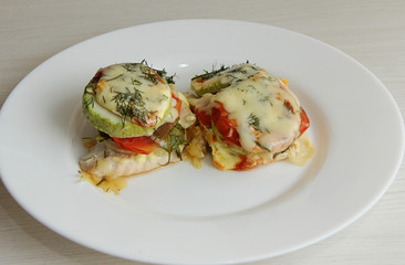 baked zucchini with vegetables on a white plate, for proper nutrition, close-up