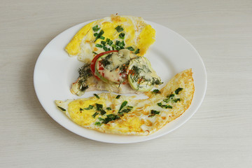baked zucchini with vegetables on a white plate, for proper nutrition, with a side dish of fried eggs decorated with herbs
