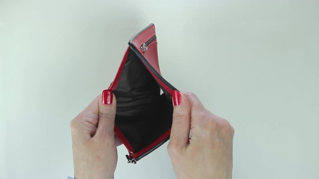 Female hands holding empty purse. Woman shows her empty wallet. Bankruptcy.
