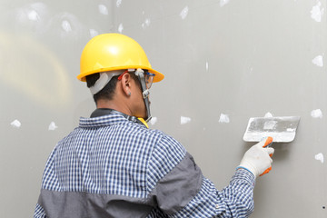 interior decoration construction furniture builtin.Plasterer in working uniform plastering the wall...
