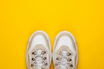Fashionable sneakers on yellow background. Top view. Minimalism