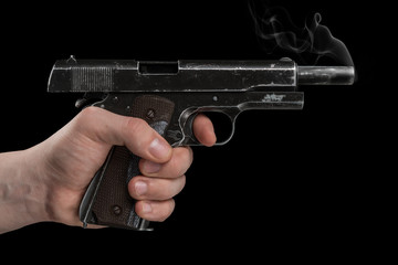 Legendary U.S. Army handgun Colt 1911A1 in male hand isolated on black background. Military model...