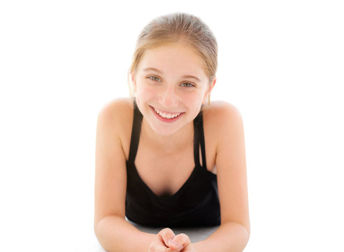 Beautiful teenager girl lying on a floor isolated on a white background