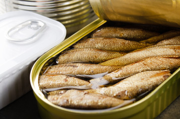 Canned smoked fish sprats in just opened tin can. Non-perishable food