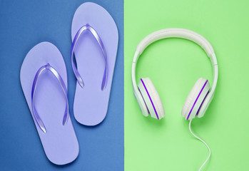 Flip flop and headphones on colored background.  Summertime relax. Summer vacation. Beauty and fashion. Top view. Flat lay