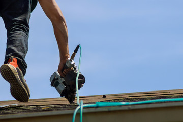Roofers workingreplacing the house installed new shingles © ungvar