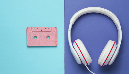 Audio cassette and headphones on purple blue background. Retro music concept. Vintage background. Disco party. Top view
