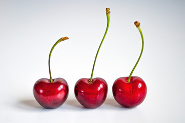 Three cherries on a white background