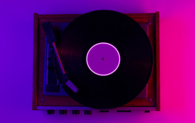 Retro style music concept. Vinyl record player with led circle ingradient pink-purple neon light. Pop culture. 80s.