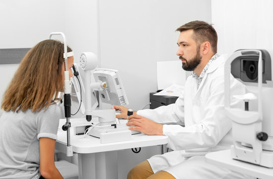 doctor examines a girl eyesight in a clinic