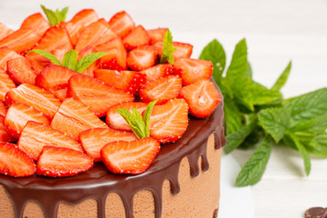 Mousse cake with profiteroles inside and strawberries