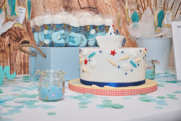 Table show idea for children birthday party food. Nautical maritime themed. Cute blue aesthetic. Sweet candy, cupcakes, cake, marshmallow... Summer beach style.