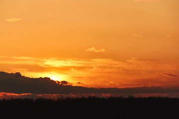 Beautiful landscape of orange evening sunset in the sky with clouds. The concept of the natural environment