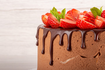 Mousse cake with profiteroles inside and strawberries