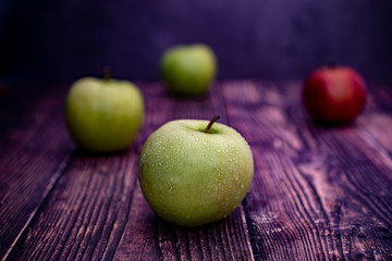 Close-up green and red apples on wooden table 
