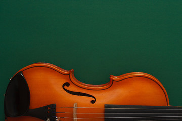 Classical music concert poster with brown color violin on dark green background with copy space for your text
