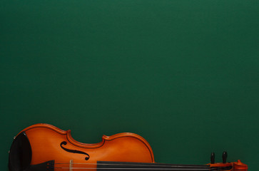 Classical music concert poster with brown color violin on dark green background with copy space for...