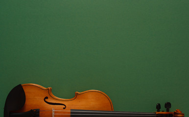 Classical music concert poster with brown color violin on dark green background with copy space for...