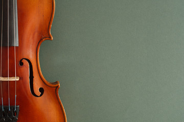 Classical music concert poster with brown color violin on dark green background with copy space for...