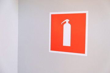 Red and white sign indicating fire hydrant on wall