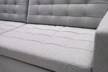 Obraz premium Grey textile modern sofa front view. Close up