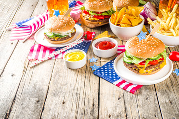 Celebrating Independence Day, July 4. Traditional American Memorial Day Patriotic Picnic with burgers,  french fries and snacks, Summer USA picnic and bbq concept, Old wooden background