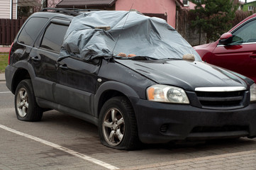 Smashed and crashed car in parking awaiting salvage and repairing.